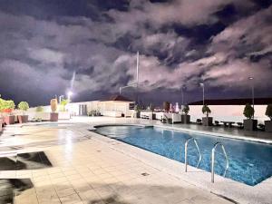 a swimming pool on top of a building at night at Tomas Morato Quezon City - Residences in Manila
