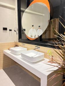 uma casa de banho com 2 lavatórios e um espelho grande em Phuzita Kohlarn-ภูศิตา เกาะล้าน em Ko Larn