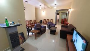 uma sala de estar com televisão e uma sala de estar com cadeiras em Nirmali Resort em Mirissa
