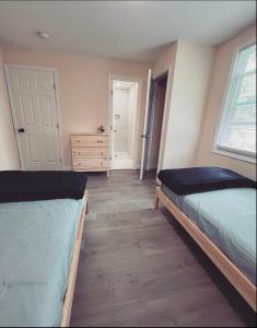 Parkville的住宿－Guest House Baltimore County Parkville，一间卧室设有两张床、一个梳妆台和窗户。