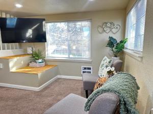 a living room with a flat screen tv and a couch at Loft Near Downtown-studio-parking -kitchenette- in Medford
