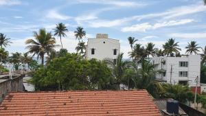 um edifício branco com palmeiras em frente em Nirmali Resort em Mirissa