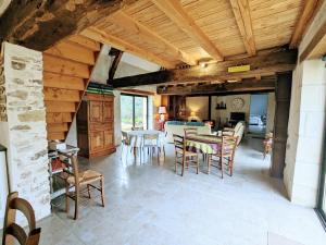 una cucina e un soggiorno con tavolo e sedie di Séjour paisible au cœur du Berry : maison familiale moderne, cheminée, jardin, et SPA à Cléré-du-Bois. - FR-1-591-563 a Cléré-du-Bois