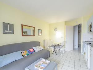 a living room with a couch and a table at Appartement T2 à 50m de la plage avec piscine et terrasse - Châtelaillon-Plage, 4 personnes - FR-1-535-50 in Châtelaillon-Plage +5 photos