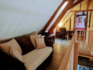 un soggiorno con divano in mansarda di Séjour paisible au cœur du Berry : maison familiale moderne, cheminée, jardin, et SPA à Cléré-du-Bois. - FR-1-591-563 a Cléré-du-Bois