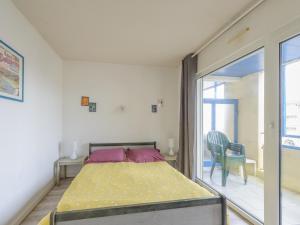 a bedroom with a bed and a sliding glass door at Appartement T2 à 50m de la plage avec piscine et terrasse - Châtelaillon-Plage, 4 personnes - FR-1-535-50 in Châtelaillon-Plage