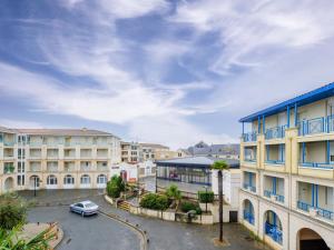 a parking lot in a city with buildings at Appartement T2 à 50m de la plage avec piscine et terrasse - Châtelaillon-Plage, 4 personnes - FR-1-535-50 in Châtelaillon-Plage
