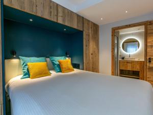 a bedroom with a large bed with blue walls and yellow pillows at Appartement Val-d'Isère, 3 pièces, 4 personnes - FR-1-694-347 in Val-d'Isère