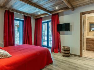 a bedroom with red curtains and a bed and a tv at Appartement Val-d'Isère, 5 pièces, 8 personnes - FR-1-694-345 in Val-d'Isère