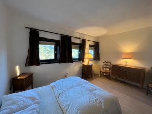 a bedroom with a bed and a desk and two windows at Appartement Villard-de-Lans, 2 pièces, 6 personnes - FR-1-761-34 in Villard-de-Lans