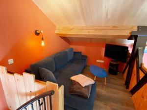 un soggiorno con divano blu e TV di Gîte Marigny-Marmande, 2 pièces, 2 personnes - FR-1-381-559 a Marigny-Marmande