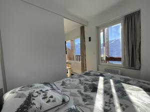 a bedroom with a bed and a window with mountains at Appartement Les Menuires, 2 pièces, 4 personnes - FR-1-452-387 in Les Menuires