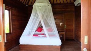 een hemelbed in een kamer bij D'Lesung Villas Lembongan in Nusa Lembongan