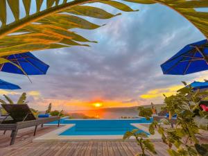 een villa met een zwembad en een zonsondergang bij D'Lesung Villas Lembongan in Nusa Lembongan