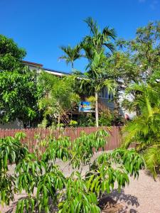 a fence with plants in front of a house at Travellers Paradise in Cairns