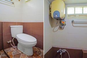 a bathroom with a toilet and a soap dispenser at OYO 92314 De Coco Guesthouse in Medan