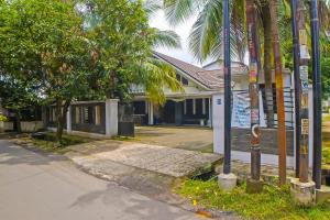 a house with palm trees in front of a street at OYO 92314 De Coco Guesthouse in Medan