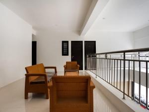 um quarto com 2 cadeiras e uma varanda em Super OYO Capital O 3463 Cimahi Guest House em Bandung