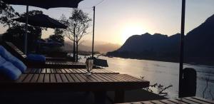 a dock on a body of water with the sun setting at Diep Le Homestay in Phong Nha