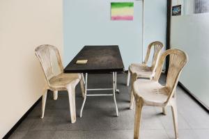 três cadeiras e uma mesa num quarto em SPOT ON 91422 Ringin Pitu 2 Syariah em Jodoh