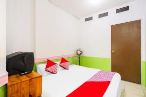 1 dormitorio con 1 cama y TV. en OYO 91344 Wr House Syariah Batam en Jodoh