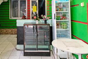 a shop with a table and a refrigerator at OYO 91757 Surya Hotel in Watansopeng