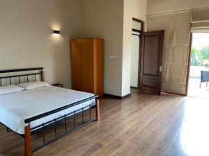 - une chambre avec un lit et du parquet dans l'établissement Spacious luxury room with beautiful views !, à Kolonnawa
