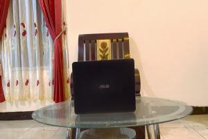 a laptop computer sitting on a glass table at OYO 92065 Kos Flobamor in Kupang