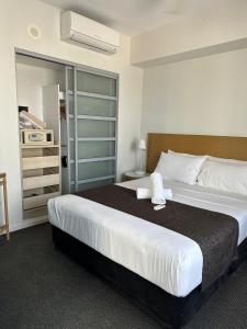 een slaapkamer met een groot bed en een kast bij Pandanas Apt 5 15th fl Darwin CBD Harbor views in Darwin