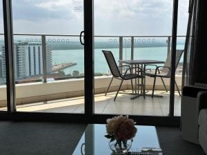 ダーウィンにあるPandanas Apt 5 15th fl Darwin CBD Harbor viewsの海の景色を望むバルコニー(テーブル、椅子付)