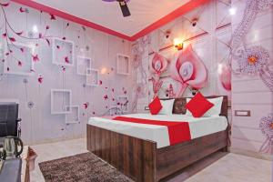 een slaapkamer met een bed en een muur met bloemen bij OYO Flagship Govind Residency in Greater Noida