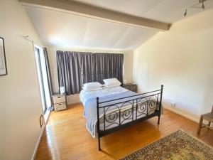 1 dormitorio con cama y ventana grande en Waterfront Retreat in Collingwood, en Collingwood