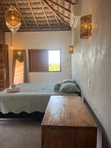 a bedroom with a bed and a wooden table at Pacas Suítes Casa & Chalés in Santo Amaro