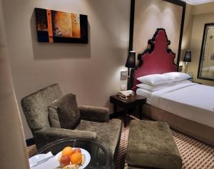 a hotel room with a bed and a table and chairs at St. Mark's Hotel in Bangalore