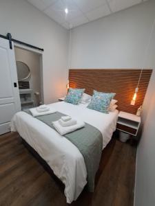 1 dormitorio con 1 cama grande y toallas. en The Stetson, en Paarl