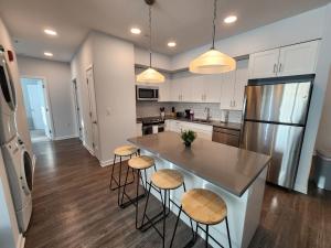 a kitchen with a counter and stools in a kitchen at Mins to NYC, Exceptional Modern 2Bedroom Apt in Jersey City