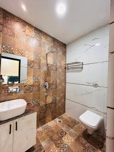 ein Badezimmer mit einem WC, einem Waschbecken und einem Spiegel in der Unterkunft HOTEL MONGA 5 Minutes From Golden Temple in Amritsar