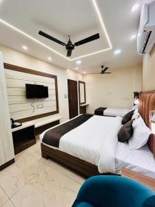 a bedroom with two beds and a flat screen tv at HOTEL MONGA 5 Minutes From Golden Temple in Amritsar