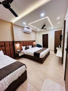 Habitación de hotel con 2 camas y TV en HOTEL MONGA 5 Minutes From Golden Temple, en Amritsar