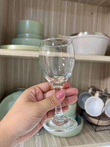 a person holding a wine glass in a kitchen at Staycation in Marilao Bulacan Near Ph Arena - Swift Escape in Marilao