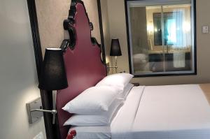 a bedroom with a large bed with a guitar headboard at St. Mark's Hotel in Bangalore