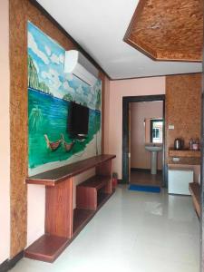 a living room with a tv and a painting on the wall at Baan Saitharn Koh Lanta in Ban Not (1)