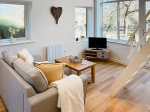 a living room with a couch and a television at Honey Bee Cottage in Welshpool