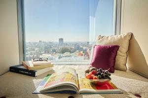 a book and a bowl of fruit next to a window at Sheraton Bucharest Hotel in Bucharest