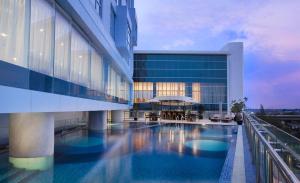 a view of a building with a swimming pool at Hariston Hotel&Suites, Pluit - Jakarta in Jakarta