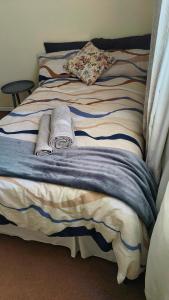ein Bett mit zwei Handtüchern darüber in der Unterkunft Saldanha BLUEWATER BAY APARTMENT in Saldanha