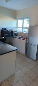 eine Küche mit einem weißen Kühlschrank und einer Spüle in der Unterkunft Saldanha BLUEWATER BAY APARTMENT in Saldanha