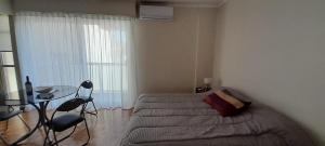 - une chambre avec un lit, une table et des chaises dans l'établissement Departamento Buenos Aires Querido, à Buenos Aires
