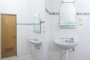 Baño blanco con lavabo y espejo en Super OYO 759 Hotel Dewi Sri en Timuran