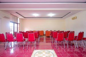 a room with red chairs and tables in a room at Super OYO 759 Hotel Dewi Sri in Timuran